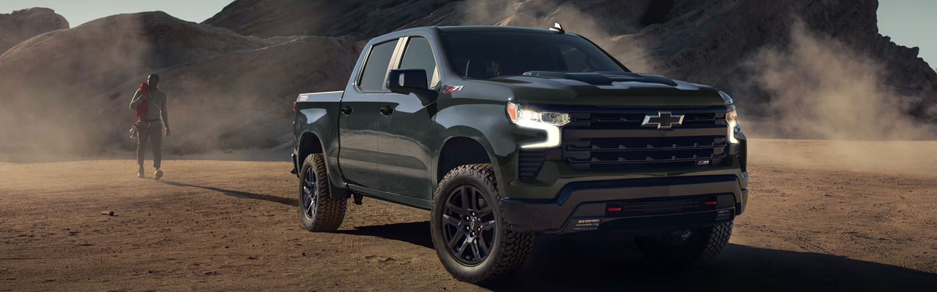 2026 Chevy Silverado pickup truck driving through a rugged desert landscape.